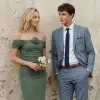 Groomsman wearing a tan suit and rose gold tie with bridesmaid in rose gold dress