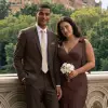 Groomsman wearing a tan suit and rose gold tie with bridesmaid in rose gold dress