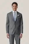 Man wearing tan Birdy Grey suit in classic fit, facing toward the camera.